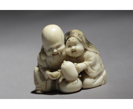 Signed Homin Con Kakihan on the base. In carved elephant tusk portraying a kneeling Okame serving tea to Fukurokuju, who is g