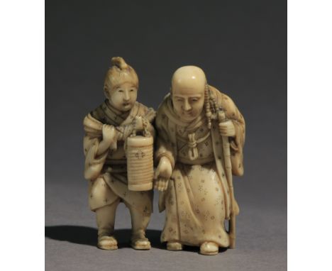 Signed Ichikosai on the back. In carved elephan tusk portraying a standing Rakan resting on a cane. On his right, a disciple 
