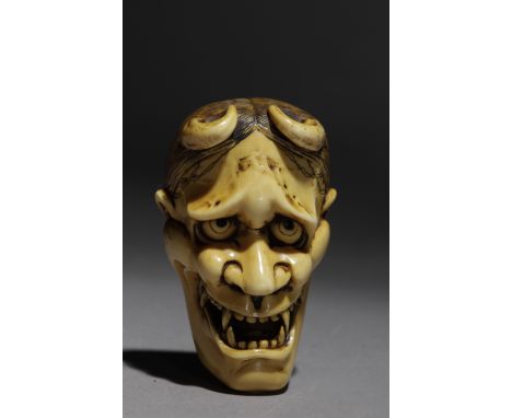 Signed Shogetsu on the back. In carved elephant tusk portraying Hannya demon mask with Okame and an Oni on the back, 46,9x29,