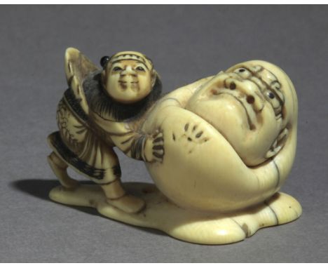 Signed Masahiro on the base. In carved elephant tusk and horn portraying a Karako pushing Yuki Daruma towards his left and le