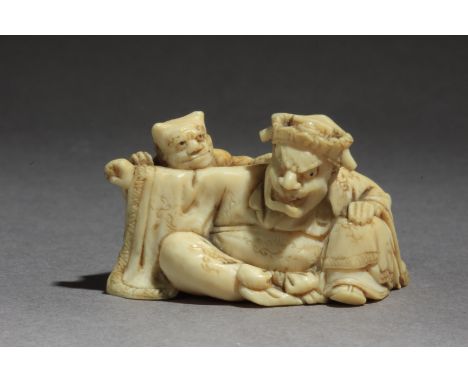 Signed Gyokkosai on the base. In carved elephant tusk portraying an Oni standing up behind a male character who is sat on the