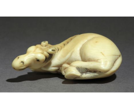 A late 18th century Japanese netsuke from Edo period. Not signed. In carved elephant tusk portraying a horse lying on the flo