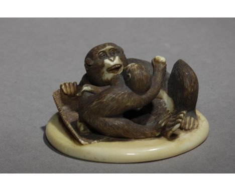 Signed Seigyoku on a mother of pearl kanji on the base. In carved elephant tusk portraying two monkeys sat on a circular shap