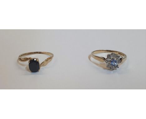 2 Sapphire 9ct yellow gold rings (2).The first a dark oval example the 2nd light blue Sapphire raised above white Sapphires.T