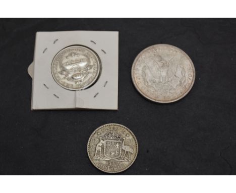 A 1927 George V Australia Silver Florin along with a 1947 George VI Australia Silver Florin and a 1900 USA Silver Morgan One 