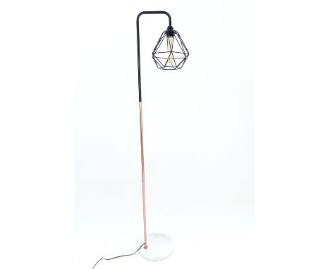 An industrial design contemporary standard lamp, with a tubular LED filament bulb and black geometric shade on a copper tubul