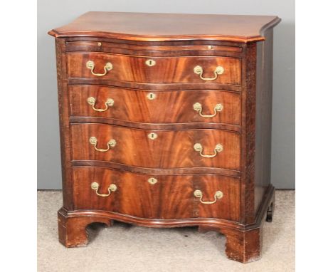 A mahogany serpentine fronted chest of drawers of Georgian design, the canted front corners with blind fret ornament, fitted 