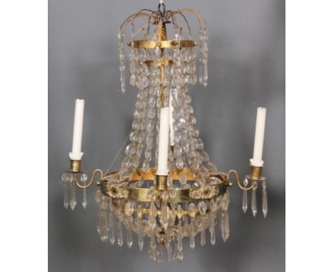 A Swedish brass framed four light chandelier, with four scroll candle branches hung with cut prismatic drops, 19ins diameter 