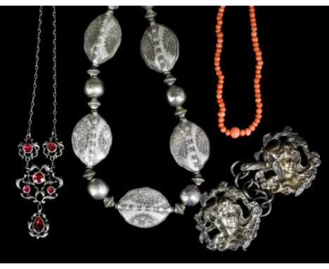 A silvery coloured metal mounted paste set necklace in the Art Nouveau manner, the scrolling face set with six red paste ston