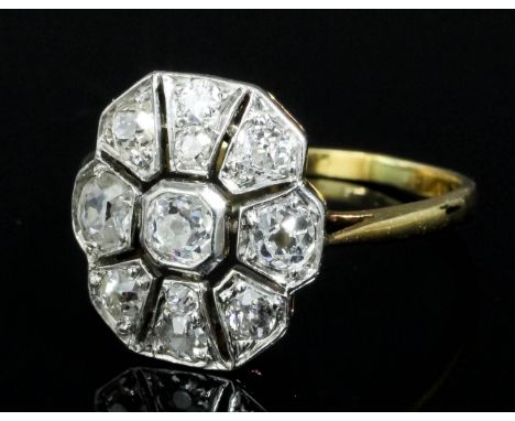 An Art Deco gold coloured metal mounted diamond set ring, the central old cut stone approximately .25ct surrounded by eight p