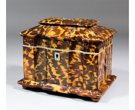 An early 19th century tortoise-shell two division tea caddy with shaped and moulded front, veneered in panels of figured tort