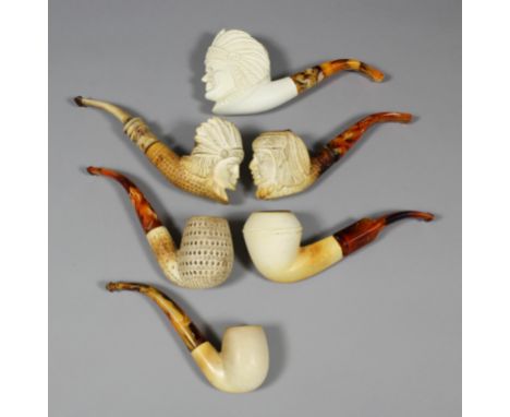 A modern Meerschaum pipe, the bowl carved with the head of an Indian Chief, with golden marbled stem, 6.25ins, two ditto, the