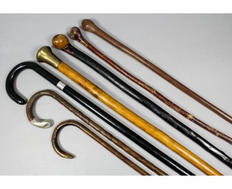 An ebonised walking stick with white metal collar, 35ins overall, and eight other walking sticks and swagger sticks, various 