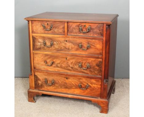 A George III mahogany chest of drawers with crossbanded top fitted two short and three long drawers, fluted pilasters to side