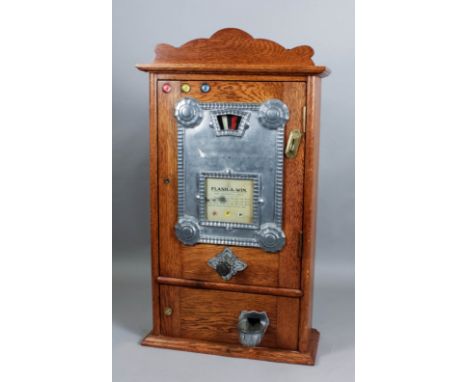 A 1930s oak cased penny-in-the-slot "Flash-A-Win" gaming machine to take 3d, 6d and 9d, with repainted colour wheel, in ornat