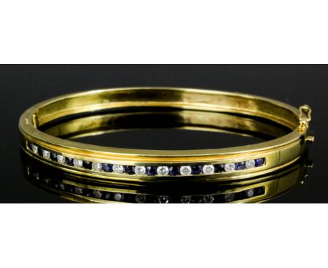 A modern 18ct gold sapphire and diamond set stiff pattern bangle by Mappin & Webb, the face set with twelve small brilliant c