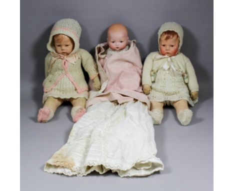 An Armand Marseille 341 bisque headed baby doll with cloth body, 12ins overall and wearing a cream christening gown, two clot