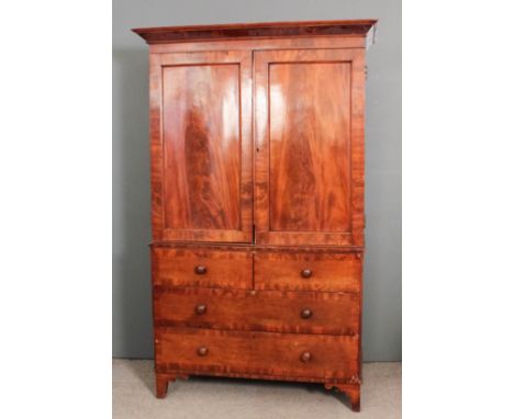 An early Victorian gentleman's mahogany break-front wardrobe, the upper part with flared cornice, fitted four sliding trays e