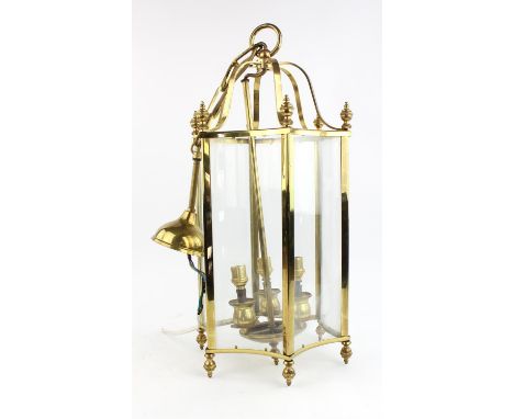 A hexagonal brass hall lantern, with six concave glass panels, 57cm high, together with a pair of smoked glass and brass hall