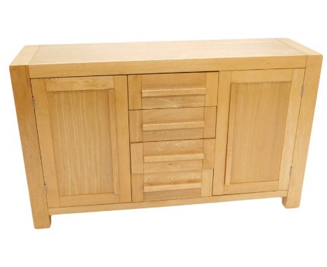 A light oak sideboard, with arrangement of four drawers and two doors, on stiles, 142cm wide. 