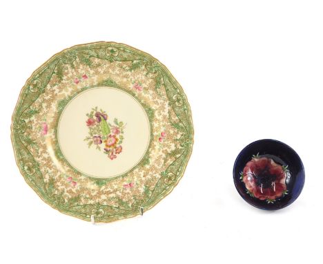 A small Moorcroft bowl, decorated centrally with a flower, on a blue ground, 11cm diameter, and a Royal Worcester plate, deco