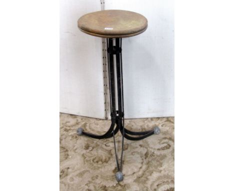 A vintage industrial work stool, with circular elm seat and raised on slatted steel, swept tripod supports