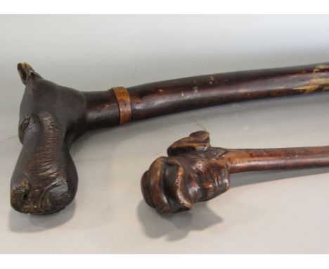 A 19th century rustic walking stick, the head with carved mount showing character in peaked cap together with a hounds head, 