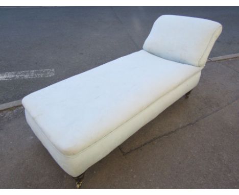 A Victorian day bed with light blue ground floral patterned upholstered finish and shaped head rest, raised on turned mahogan