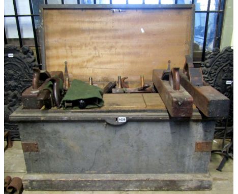 A 19th century stained pine carpenters tool chest with hinged lid containing a quantity of related tools including a number o