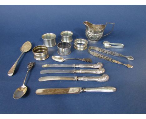 A collection of various silver items to include five napkin rings,, cream jug, two sugar nips, two crested spoons, stylised s