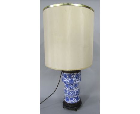 A late 19th century blue and white printed two sectional ceramic lamp base, with stylised floral decoration, raised on a base
