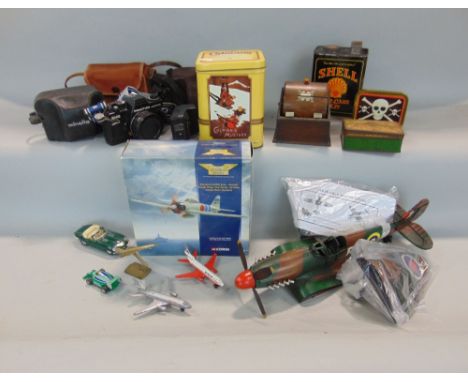 A tin plate model of a Spitfire, with painted finish, never assembled, a timber cigarette dispenser, a number of tins and cam