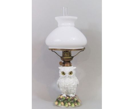 Continental porcelain figural oil lamp in the form of a standing owl, the opaline shade on a brass framework, the owl on a na