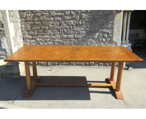 A good quality contemporary refectory dining table with well matched veneered panelled top raised on four turned supports and