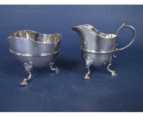 Late Victorian silver embossed banded wavy rim milk jug and sucrier, with cabriole hoof spade feet, maker JHR, London 1897, 1