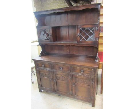 A reproduction oak dresser, possibly JC or Old Charm, the base enclosed by three panelled doors and three drawers, beneath a 