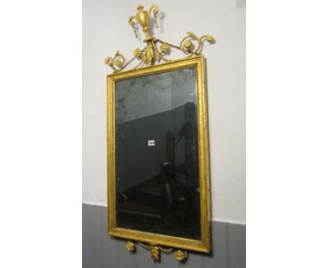 A 19th century wall mirror of rectangular form with beaded slip and moulded frame, beneath a raised urn and scrolling foliate