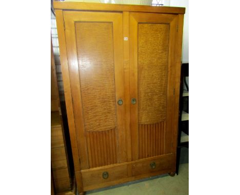 An art deco style two door wardrobe, in mixed woods including rippled ash, the panelled and fluted doors over two frieze draw