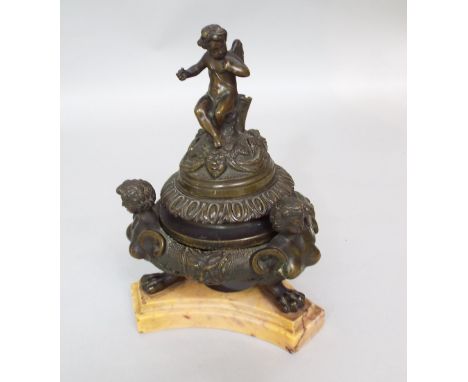 A 19th century Grand Tour bronze inkwell and cover, the finial surmounted by a winged cherub over three monopodia style suppo