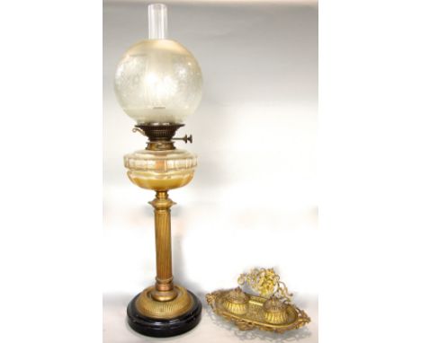 A brass column table standing oil lamp with cut glass font, twin burner and etched glass globe, together with a cast brass in