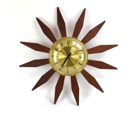 An Anstey &amp; Wilson 'sunburst' or 'starburst' clock, the simple teak rays shooting out from a plain brass face with Arabic