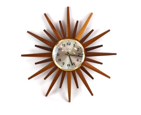A Eurastyle 'starburst' or 'sunburst' clock with alternating teak rays around a plain silvered face with Arabic numerals, d. 