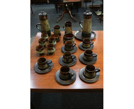 A Celtic pottery tea and coffee service with green and orange decoration on black ground, comprising coffee pot and cover, mi