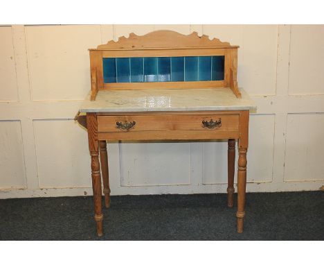 A Victorian pine washstand, blue tile back over white marble top, with single long drawer, on turned legs, 90cm wide