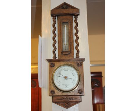 A Negretti & Zambra, London, oak cased wall barometer with thermometer, the dial marked R/19340, the case with carved roundel