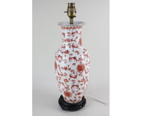 A porcelain baluster table lamp with red foliate decoration on white ground, mounted on hardwood stand, 34cm high including b