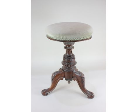 A Victorian piano stool with circular upholstered seat, on carved baluster support and tripod base