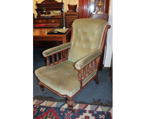 A Victorian oak framed button back armchair with carved bulbous supports and legs on castors, in green velvet upholstery