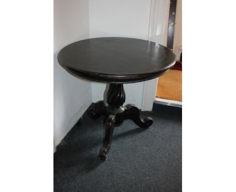 A black painted mahogany circular side table on carved baluster stem and outswept tripod legs, 74cm