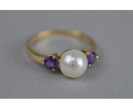 A PEARL AND AMETHYST 14CT YELLOW GOLD RING, the centre cultured pearl diameter approximately 7.8mm, with small mixed  cut ame